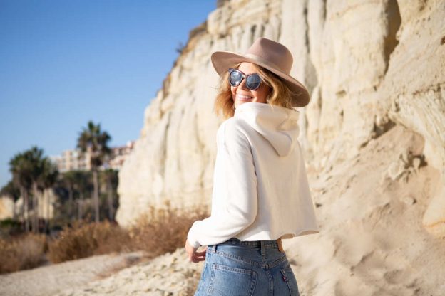 smiling girl wears elegant beige summer hat