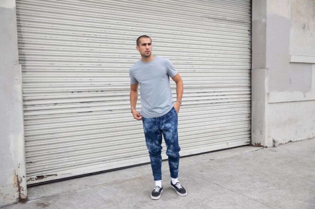 a man with grey t-shirt is standing on the street