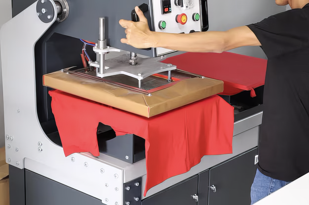 A man uses a heat press machine to transfer DTF prints onto a t-shirt.

