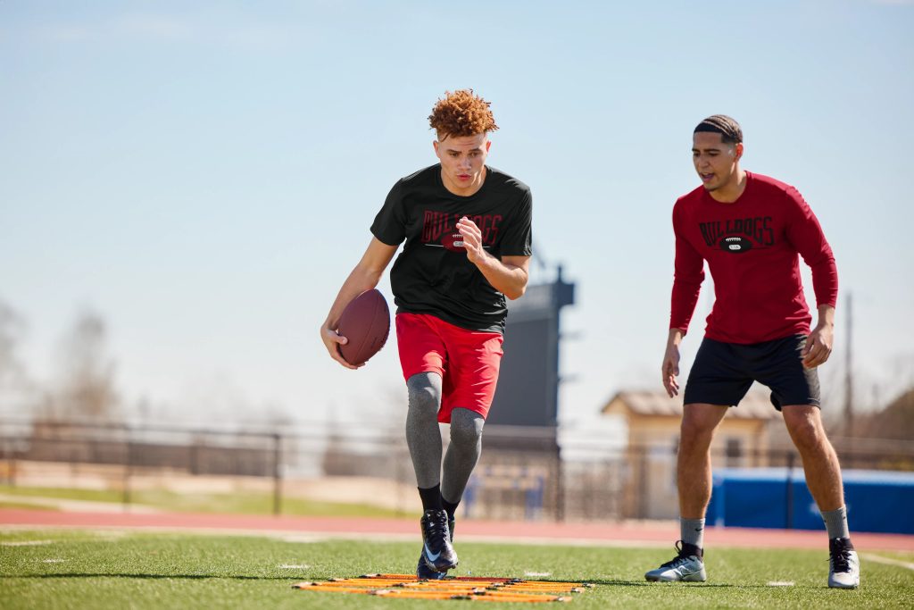 Rugby players wearing Sport-Tek ST730 Re-Compete Fleece Pullover Hoodie, built for warmth and performance on and off the field